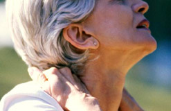 A woman clutches her neck in pain