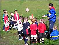 Team huddle up as their coach talks to them.