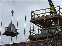 Piece of clock tower being hoisted