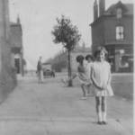 Irene M. M. Taylor in a Street just off Liverpool Road, Eccles circa 1931 with Jack Ormesher close by his soft-top car and two local children in on the photo