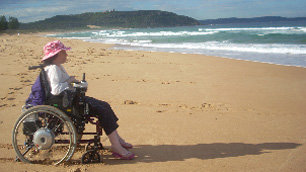 A very grumpy Liz Carr on the beach in Australia