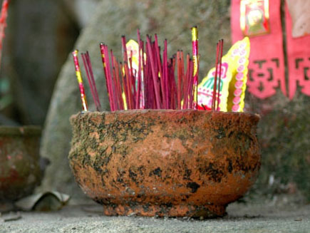 Incense sticks in a clay pot on stone steps