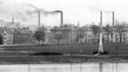 Black and white view from Moncrieff Island showing the North Inch, with smoking industrial chimney stacks behind.
