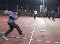 Boy playing football at night