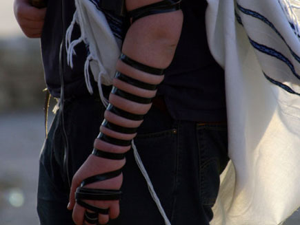 Close up of Tefillin wrapped around a Jewish man's left arm