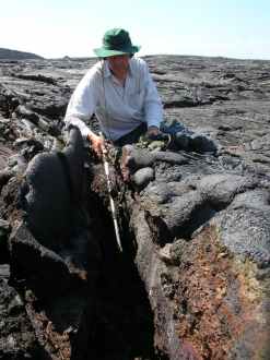 Wildlife sound recordist Chris Watson recording deep inside a lava fissure on the Galapagos islands. © Joe Stevens.