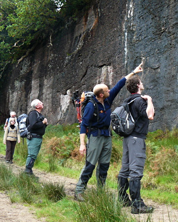 Mountain leader Wally Wallace points at some holds on the 'blue rocks'