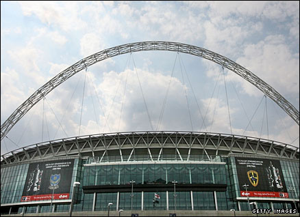 The logos of Portsmouth FC and Cardiff City FC hang on the side of Wembley stadium in preparation for the FA Cup final