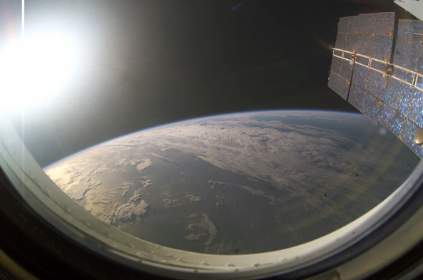 Setting Sun on Earth's Horizon Framed by Solar Array Panels
