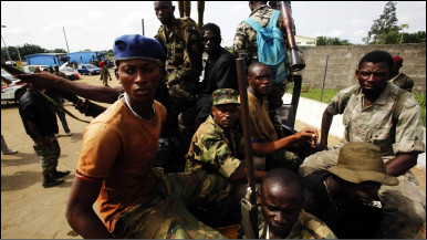 Soldiers loyal to Ivory Coast presidential claimant Alassane Ouattara ride a vehicle through the main city Abidjan April 6, 2011