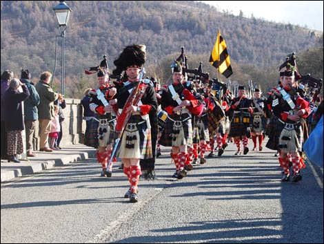 Pipers lead the parade over Dunkeld Bridge