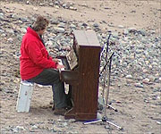 Mark Horton taking part in the experiment by playing the piano on the beach