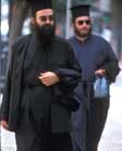 Greek Orthodox priests wearing beards, black robes and flat-topped hats