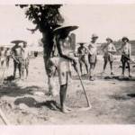 Native coolies on the strip being given a little encouragement by one or two of the chaps.