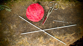 Knitting materials - two double pointed needles, ball of yarn, scissors and darning needle