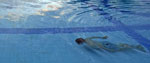 A man swimming underwater in a swimming pool
