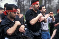 Shi'a men wearing red headbands in an Ashura parade