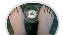 Close-up of a person's feet as they weigh themselves on bathroom scales