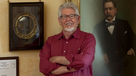 Rolf Harris at Cyfarthfa Castle Museum in front of portraits by his grandfather GF Harris