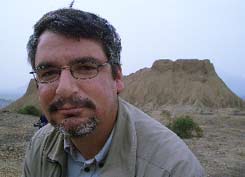 Archaeologist Luis Jaime Castillo sitting in front of a Moche pyramid