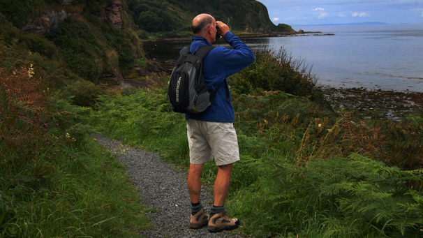 Paul Williams looking through binoculars at Bracken Bay