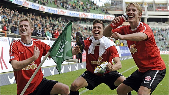 Mainz's Andre Schuerrle, Adam Szalai and Lewis Holtby celebrate with the corner flag after beating Werder Bremen