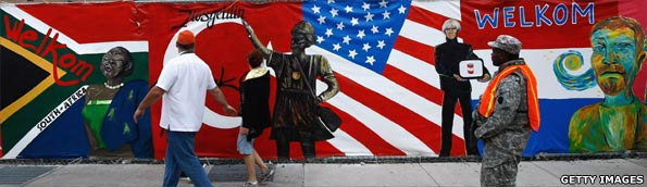 A National Guardsmen and local residents pass by a welcome mural near the site of the G20 summit on 24 September, 2009 in downtown Pittsburgh, Pennsylvania