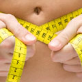 Close-up image of a woman measuring her waist
