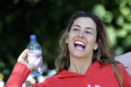 Woman laughing, holding a bottle, photo by Tom Ang