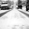 Cars in a suburban street covered in snow