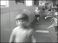 small boy walking down a corridor