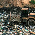A digger moving rubbish on a landfill site