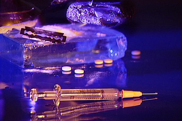 Image of syringe and surrounding drugs