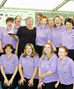 Cyntaf, aelodau o G&ocirc;r Alawon Gwerin Newyddion Da, Clunderwen gyda eu arweinydd Marilyn Lewis