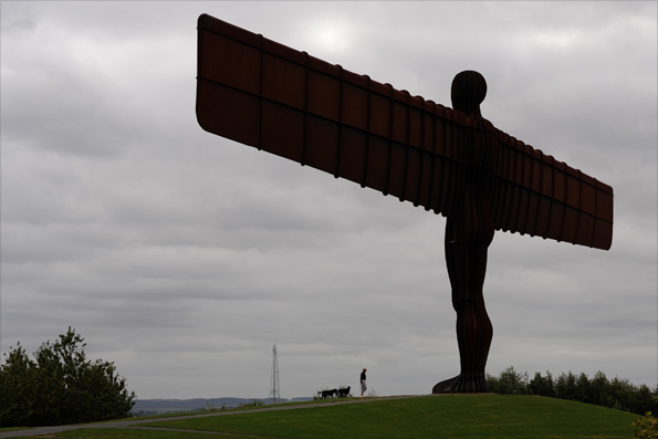 Zoe McManus and her dogs beside the Angel of the North