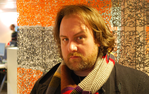 Mitch Benn in front of a colourful wall