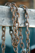 Chains hanging over wooden fence
