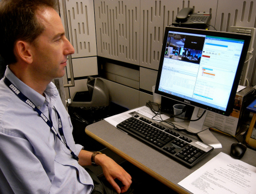 John Fletcher is pictured sitting at a computer terminal, using the Ingex software to manage the ingest of video and audio content during a recording of The Bottom Line
