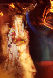 Performer in white costume and bright white makeup with a blue-painted Blue Man in the foreground