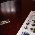 Dining table, showing the damage caused by planning the D-Day embarkations in Falmouth, and original postcard of The Haven hotel