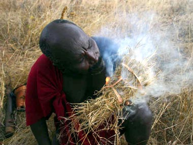 A local man creates smoke to relax the bees.