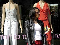 A woman standing outside a fashion store