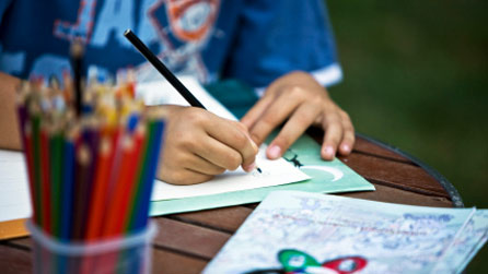 Plentyn yn tynnu llun gyda phensil