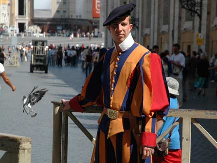 A ceremonial guard wears a bright orange, blue and red Renaissance-style uniform with a black beret