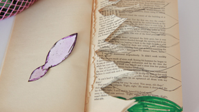 A book with leaf shapes cut from the pages
