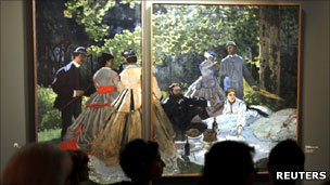 People passing a Monet painting at an exhibition at the Grand Palais, Paris