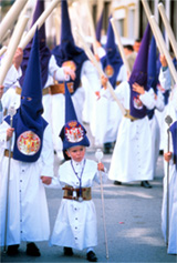 Adults and children dressed in bright blue hoods at a Spanish Holy Week festival