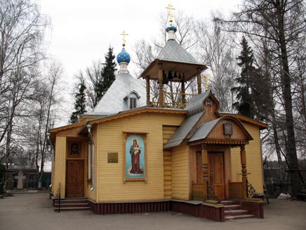 Father Alexander's church, a tiny, square wooden building with neat steep-angled roofs and small blue domes and a painted icon of the Virgin and Child next to the door